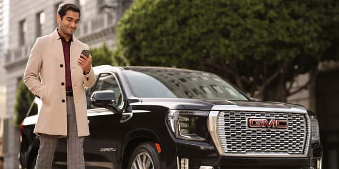 Man on phone next to GMC yukon