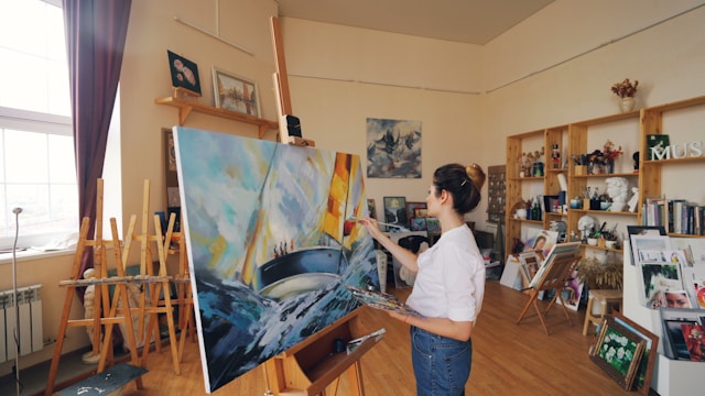 A woman paints a painting in her studio