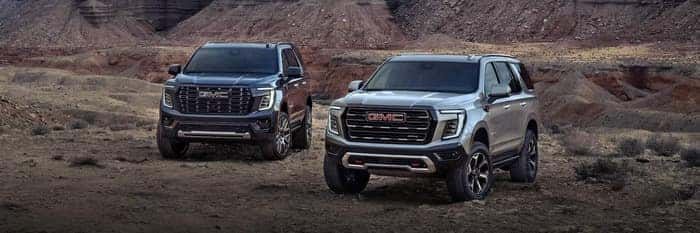 2 GMC Yukons parked in the grass