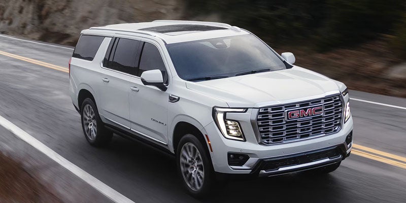 White 2026 GMC Yukon driving on road