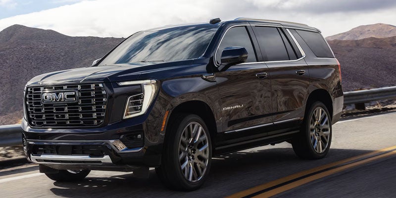 Black 2026 GMC Yukon Denali driving on road