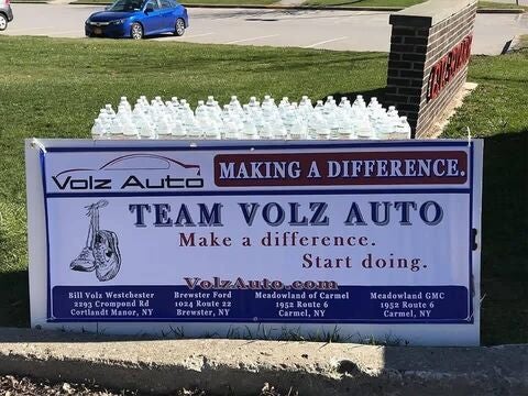 Team Volz Auto banner displayed with water bottles on the grass.
