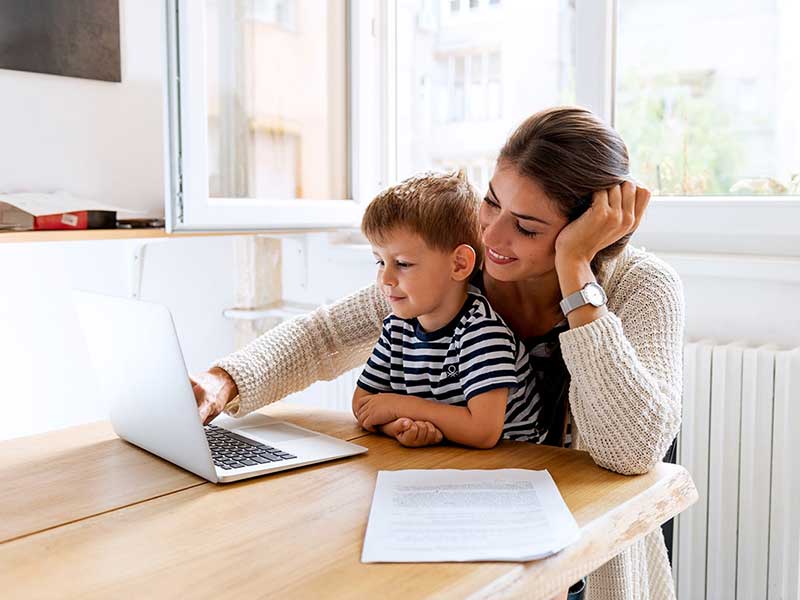 woman with child using laptop at home